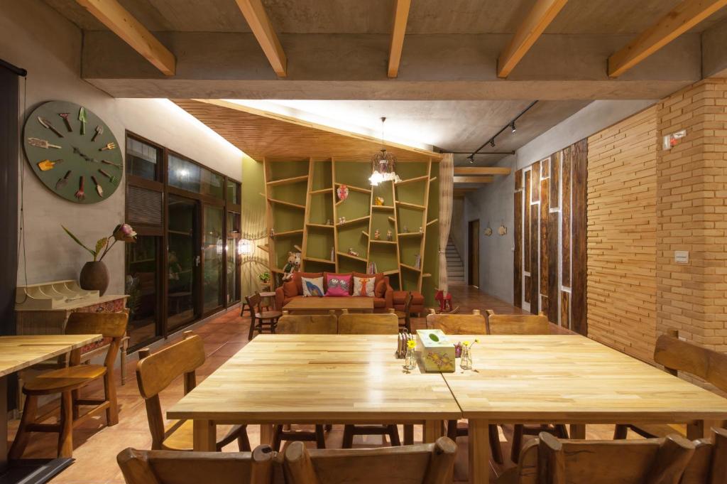 Habitación con una gran mesa de madera y un reloj. en Muho B&B, en Dongshan