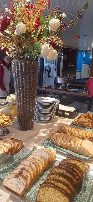 Natalina Pousada & Restaurante في نوفا ترينتو: طاولة مليئة بالكثير من أنواع الخبز المختلفة