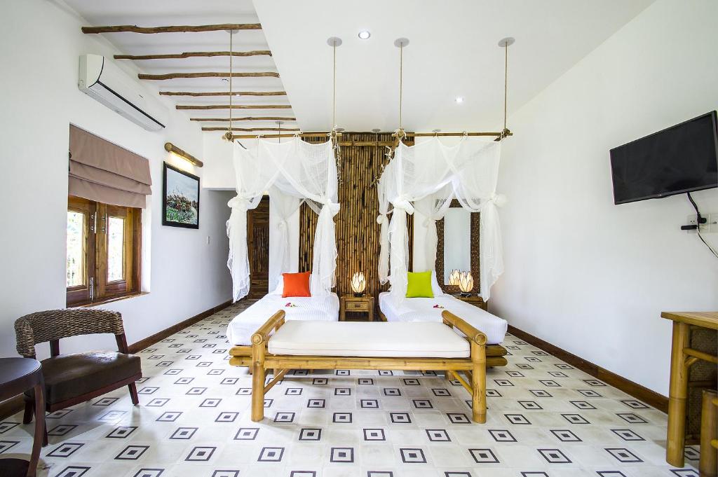 a bedroom with a bed and a tv on a wall at The Island Lodge in Mỹ Tho