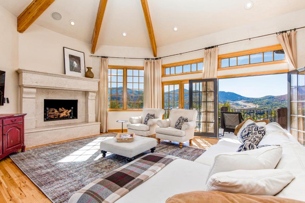 a living room with a white couch and a fireplace at Modern Hillside Manor in Park City