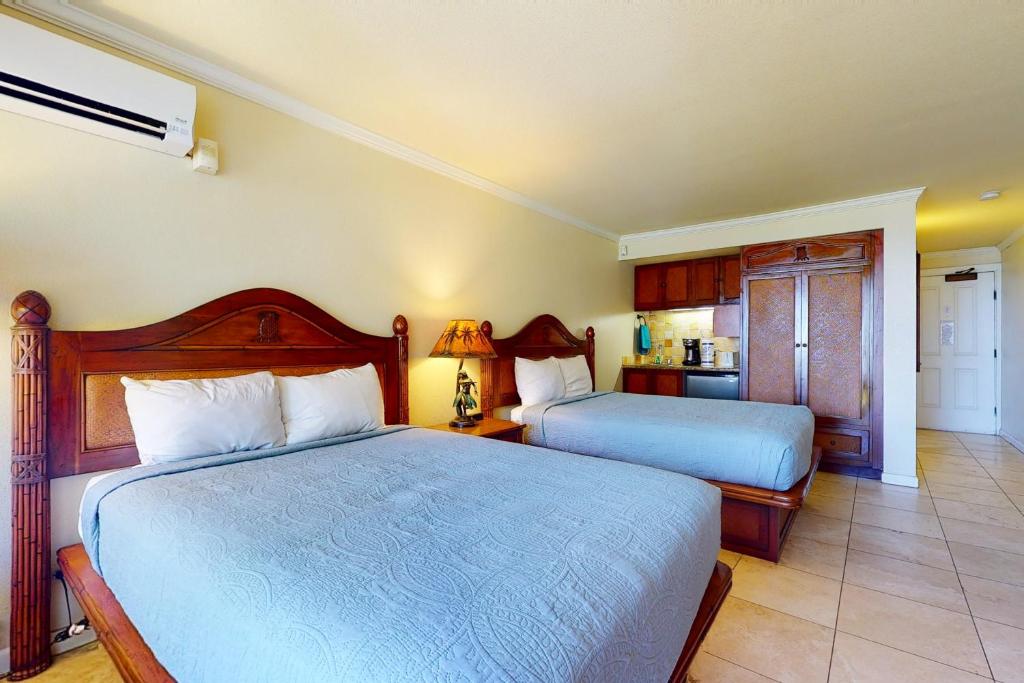 um quarto com 2 camas e uma cozinha em Islander on the Beach 211 em Kapaa