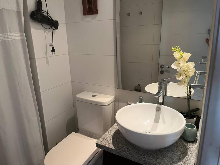 a bathroom with a sink and a toilet and a mirror at Reñaca Park II 2d 2b in Viña del Mar
