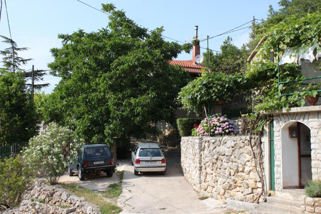 dos autos estacionados frente a una casa en Apartments by the sea Merag, Cres - 7877, en Cres