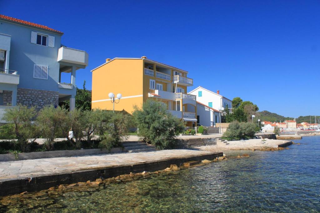 a row of houses next to a body of water w obiekcie Apartment Preko 8384c w mieście Preko