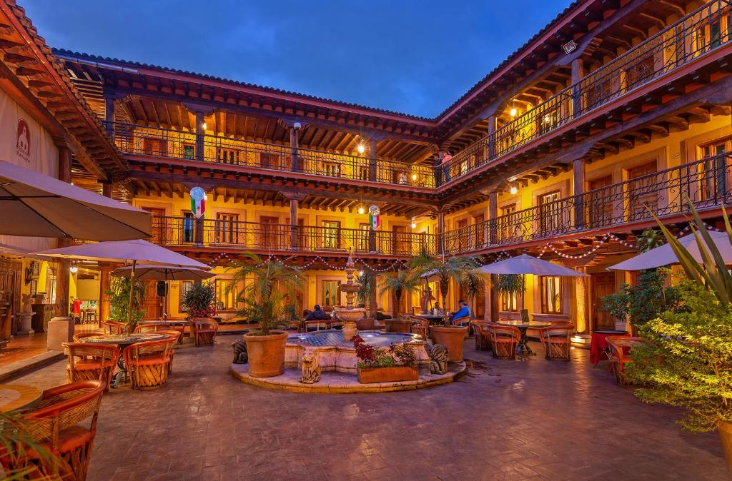 un patio al aire libre con mesas y sillas y un edificio en Hotel la Parroquia en Pátzcuaro