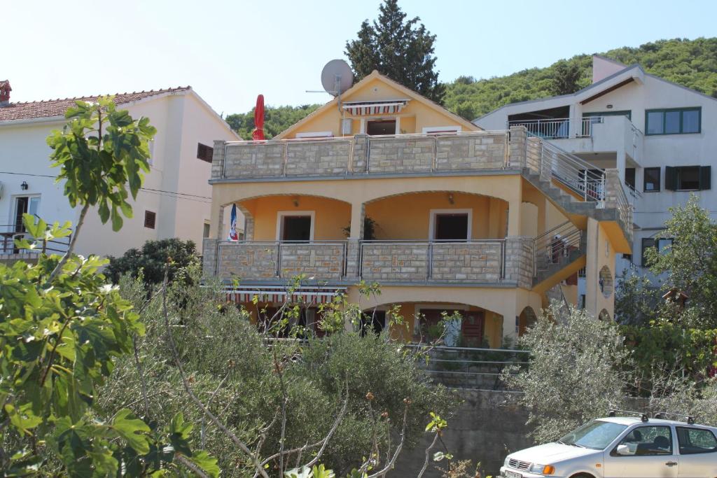 ein gelbes Haus mit Balkon darüber in der Unterkunft Apartments with a parking space Preko, Ugljan - 8428 in Preko