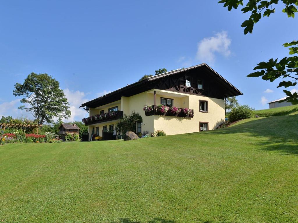 a house on a hill with a large yard at Spacious Apartment in Drachselsried Germany With Sauna in Drachselsried