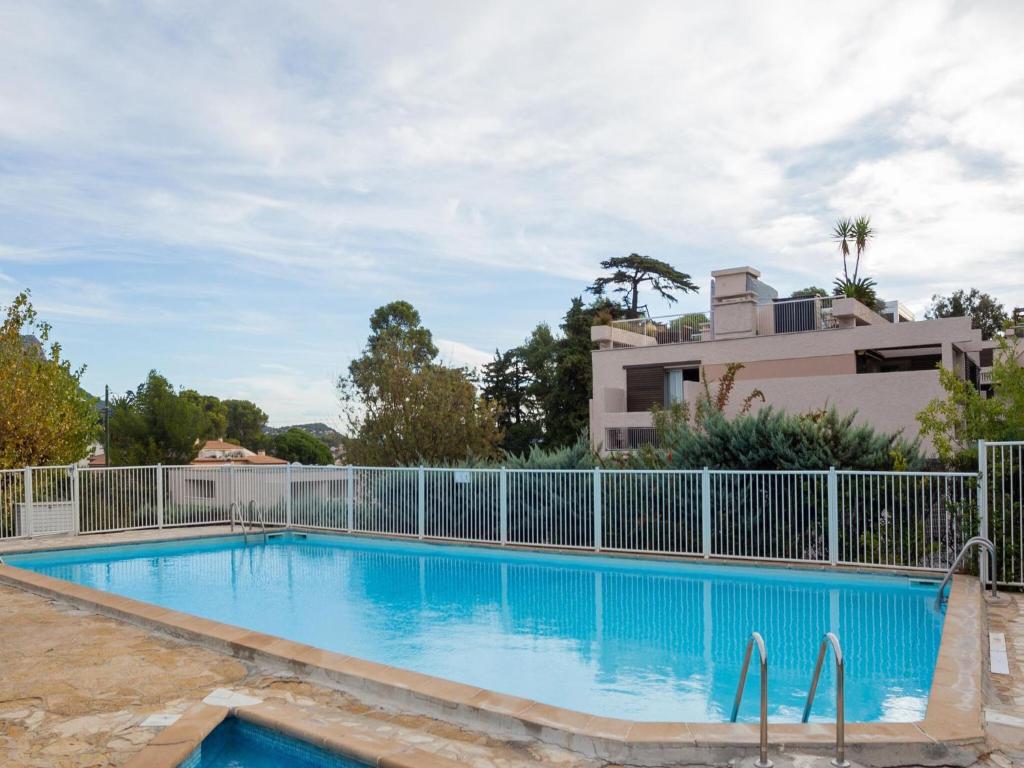 ein Pool mit einem Zaun und einem Gebäude in der Unterkunft Elegant holiday home with pool in Toulon