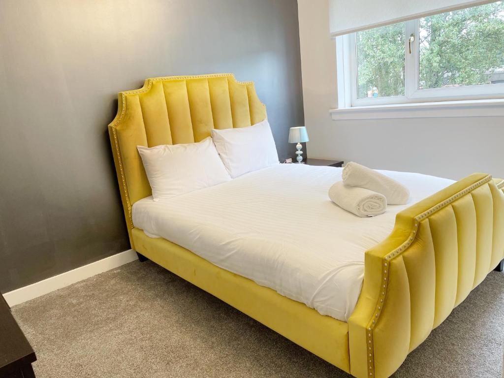 Cozy Nights - Shawholm Cr في Mansewood: سرير أصفر مع اللوح الأمامي الأصفر في غرفة النوم