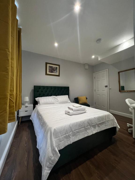 a bedroom with a bed with two towels on it at Dunstable Boutique Guest House in Dunstable