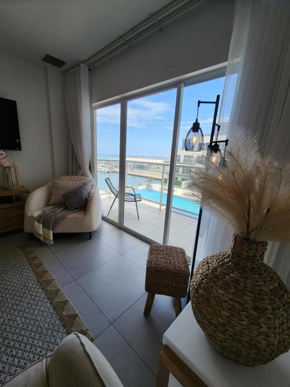 sala de estar con sofá y jarrón con planta en ARUBA DREAM GETAWAY 2BR/2BT OCEAN & POOL VIEW, en Oranjestad