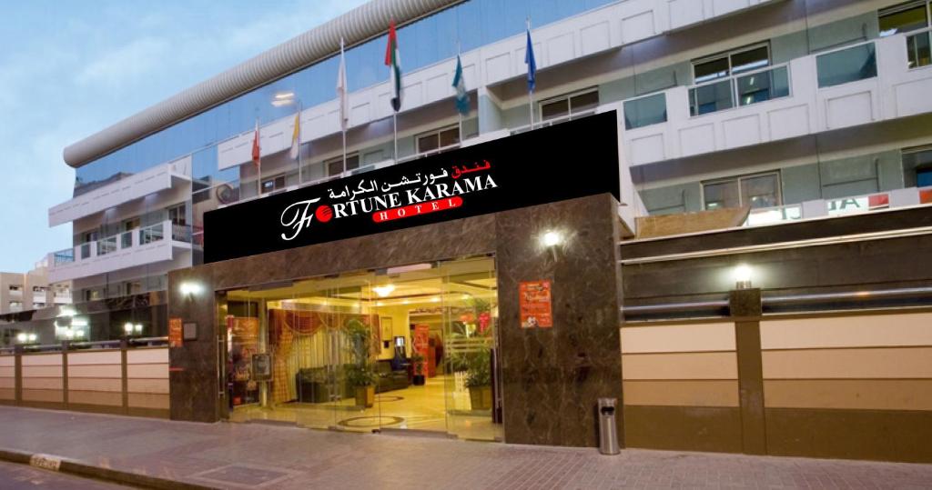 una tienda frente a un edificio con un cartel. en Fortune Karama Hotel en Dubái