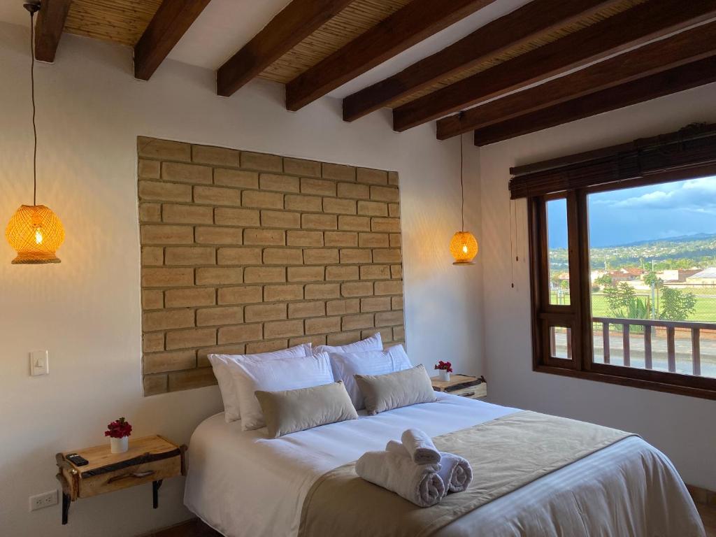 a bedroom with a large bed with a large window at Hotel Alandalus in Villa de Leyva