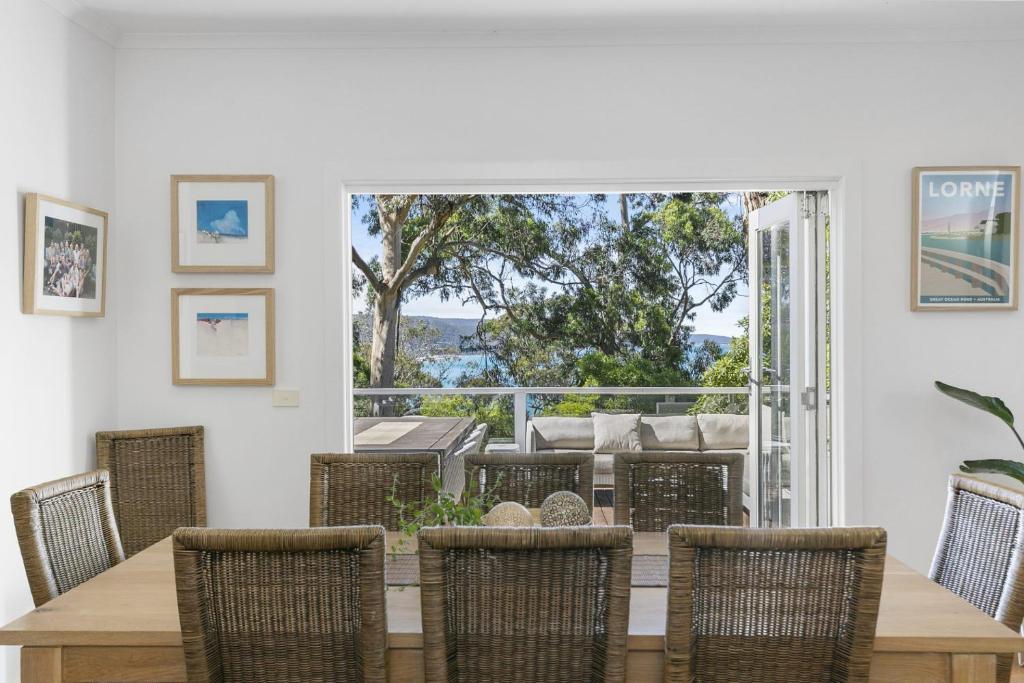 a dining room with a wooden table and chairs at Whitecaps in Lorne