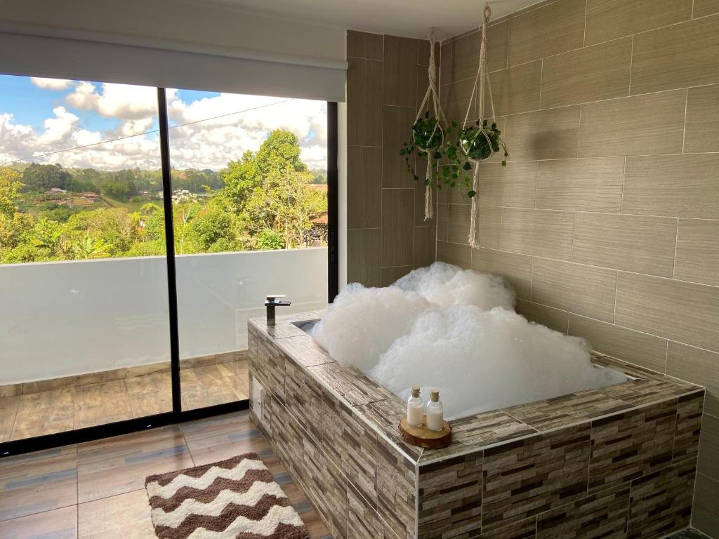 a bathroom with a bath tub filled with snow at Cabañas con jacuzzi y chimenea - Casa Floral, Marinilla in Marinilla