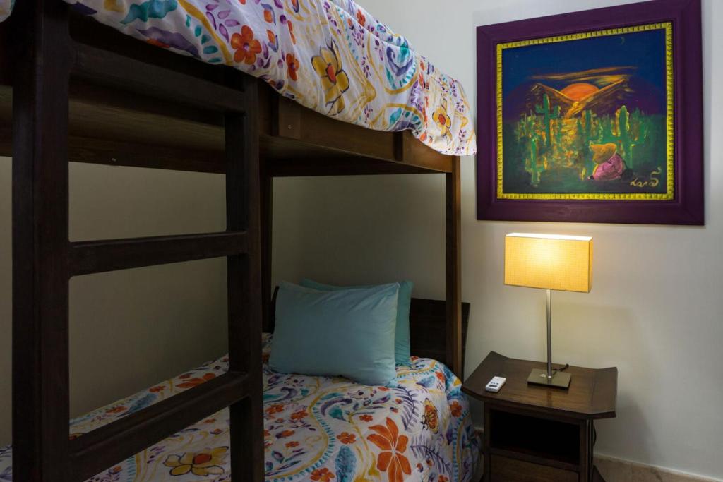 a bedroom with a bunk bed and a lamp at Paseo del Sol Condohotel by BVR in Playa del Carmen