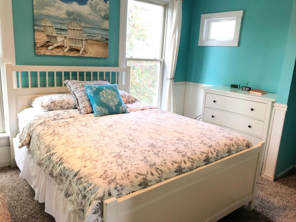 Un dormitorio con una cama con paredes azules y una ventana en The Lodge Dog and Family Friendly 5 Bedrooms 13 guests 10 beds, en Saint Peter