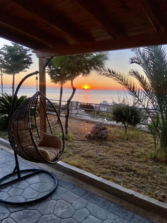 a hanging chair with the sunset in the background at Villa Rose in Archangelos