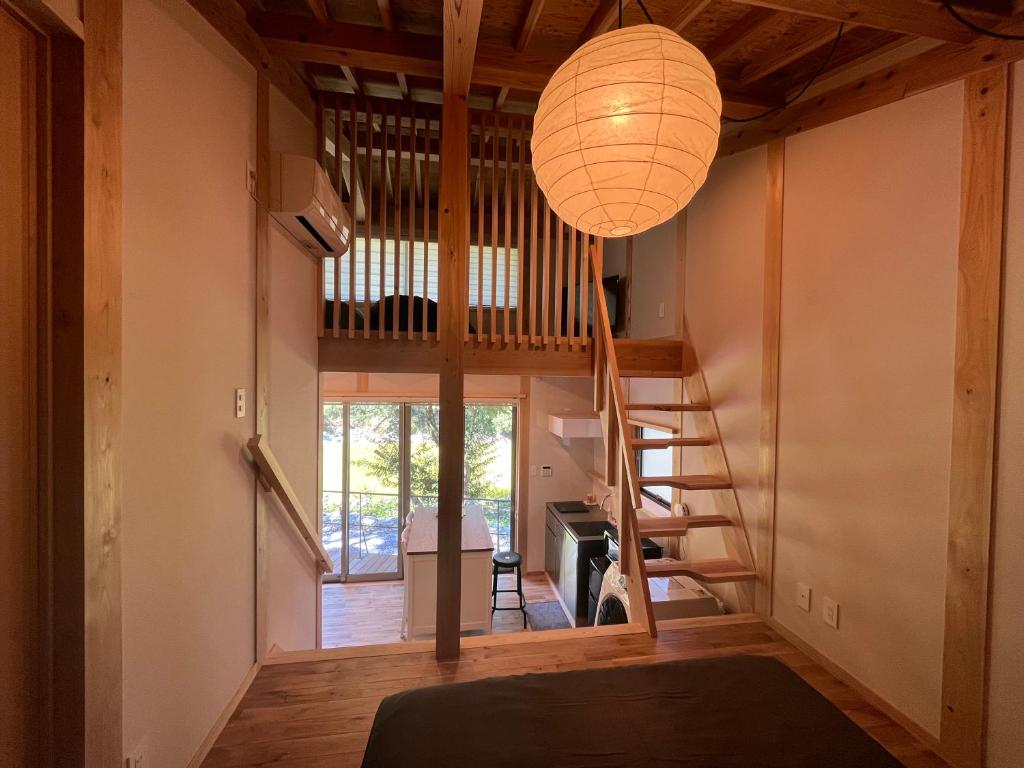 Habitación con escalera y lámpara de araña. en CrossFit Otoyo Strength TINY HOUSE en Otoyocho