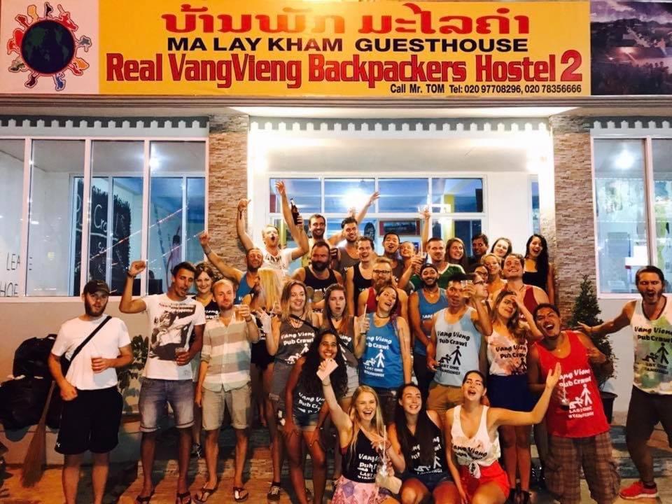 萬榮的住宿－Vang Vieng Freedom View Hostel，一群人站在一座建筑物前摆着一张照片