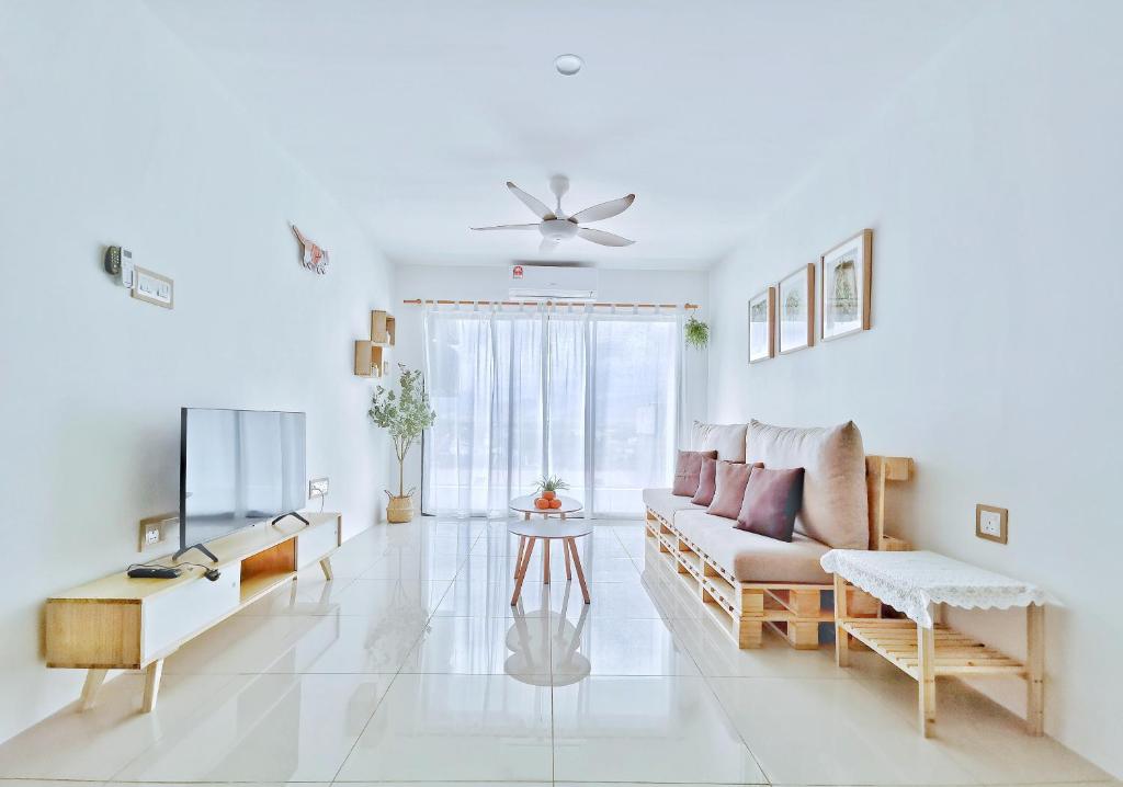 a white living room with a couch and a tv at One Life Four Season Waterpark Guest House Manhattan Condominium in Ipoh