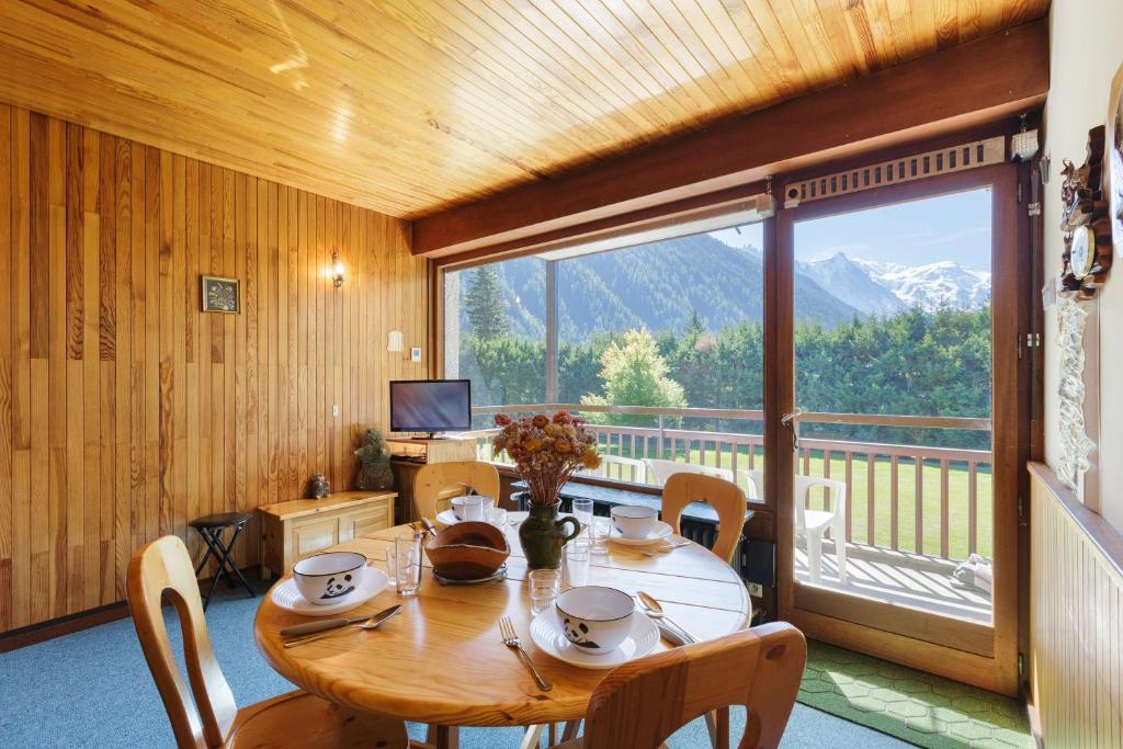 a dining room with a table and a large window at Résidence Grands Montets 221 ski in-ski out - Happy Rentals in Chamonix