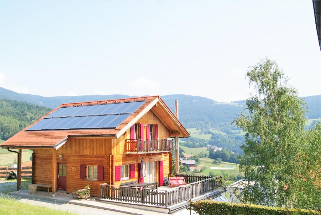 Pöllauberg的住宿－Ferienhaus in ruhiger Lage - 3 Schlafzimmer- große Terrasse，屋顶上设有太阳能电池板的房子