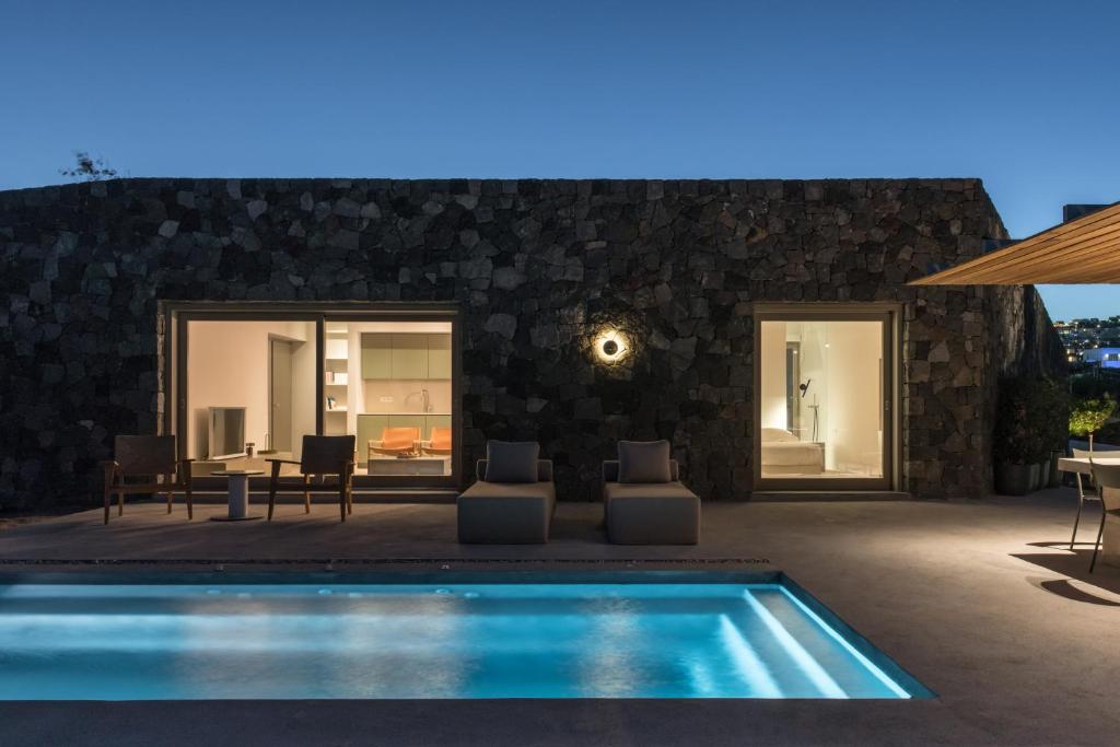 a villa with a swimming pool in front of a house at Aesthesis Boutique Villa Trace in Fira