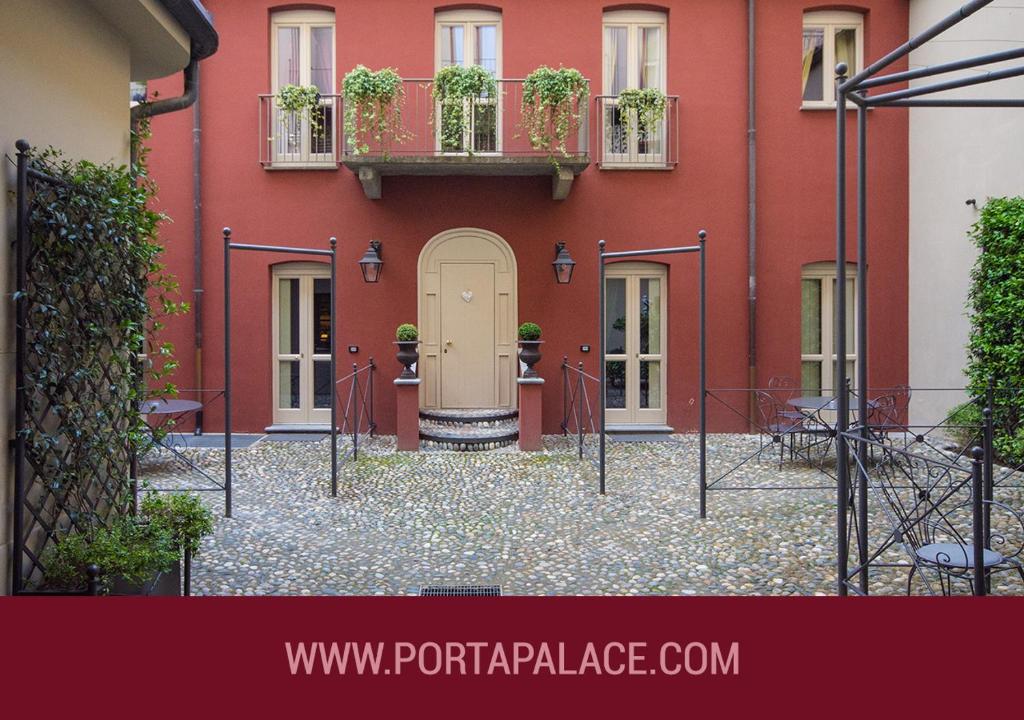 un edificio rosso con piante in vaso alle finestre di Porta Palace Apartments a Torino