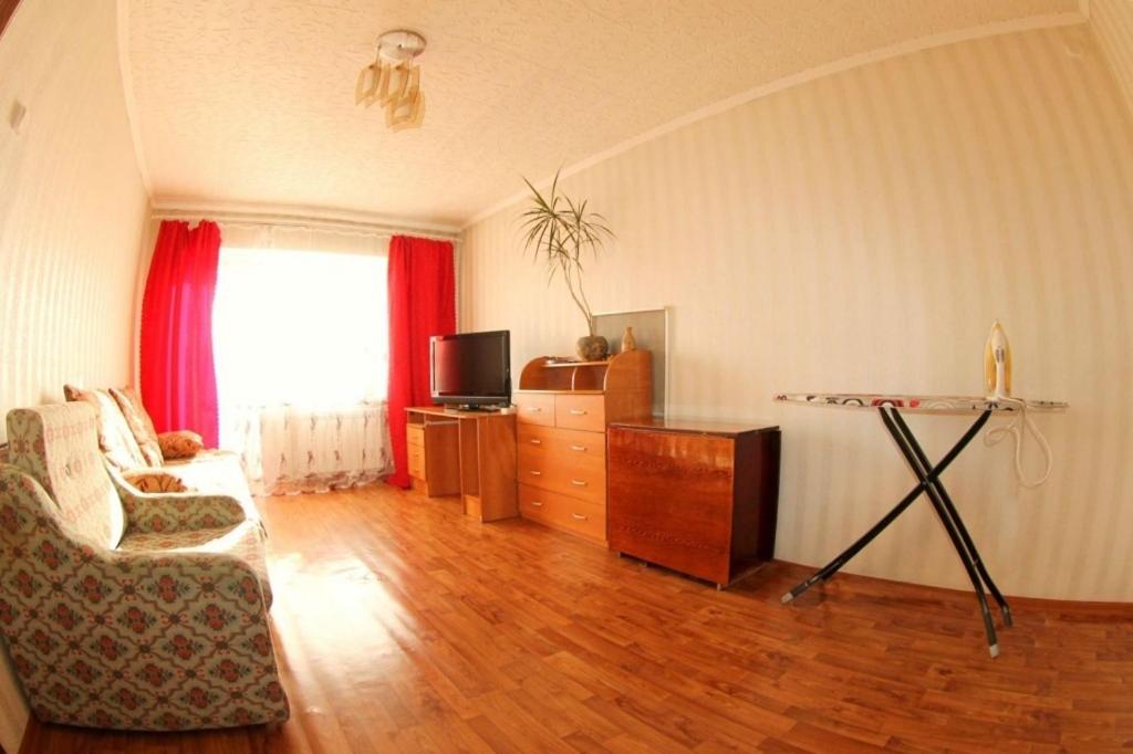 a living room with a couch and a table and a television at Dekabrist apartment at petrovsko-zavodskaya 31 in Chita