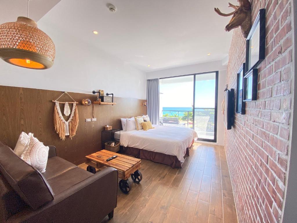 Minimi Inn-Sailrock Beach House في Eluan: غرفة نوم بسرير واريكة في غرفة