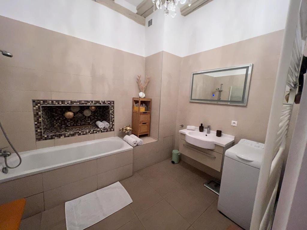 a bathroom with a bath tub and a sink at Gite BI UNS chez Silvana in Colmar