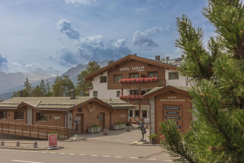 un edificio con una señal delante de él en Hotel Sarain Active Mountain Resort, en Lenzerheide