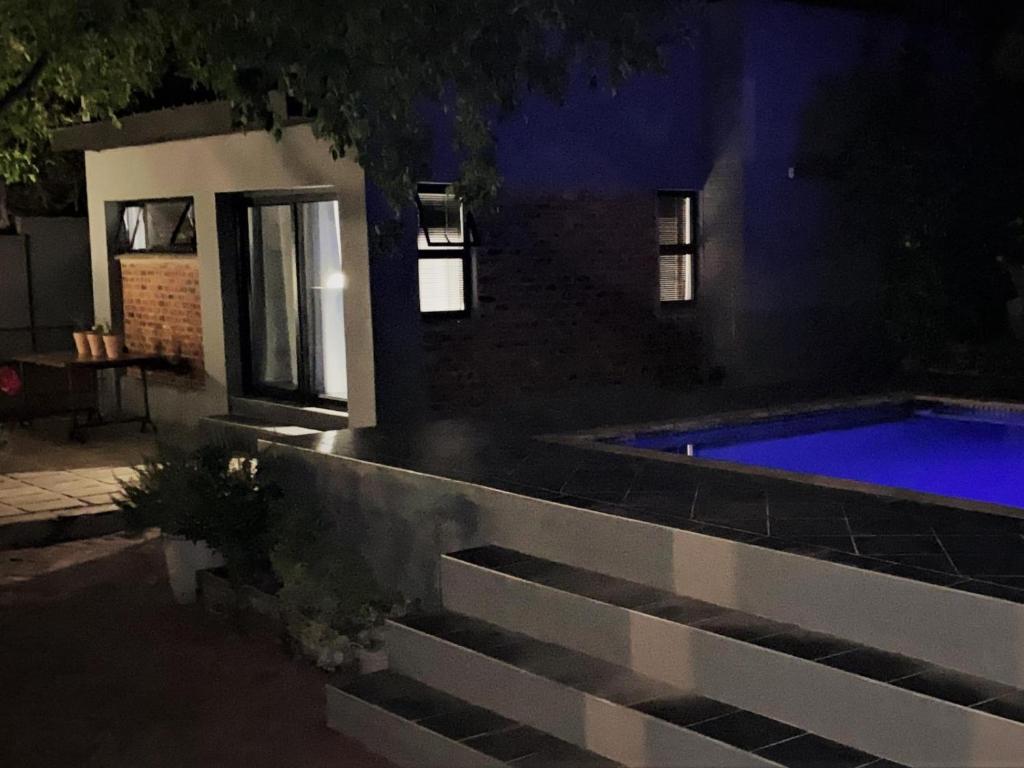 a house with a swimming pool at night at 46 on Allcock Guest Apartment & Luxury Room in Pretoria