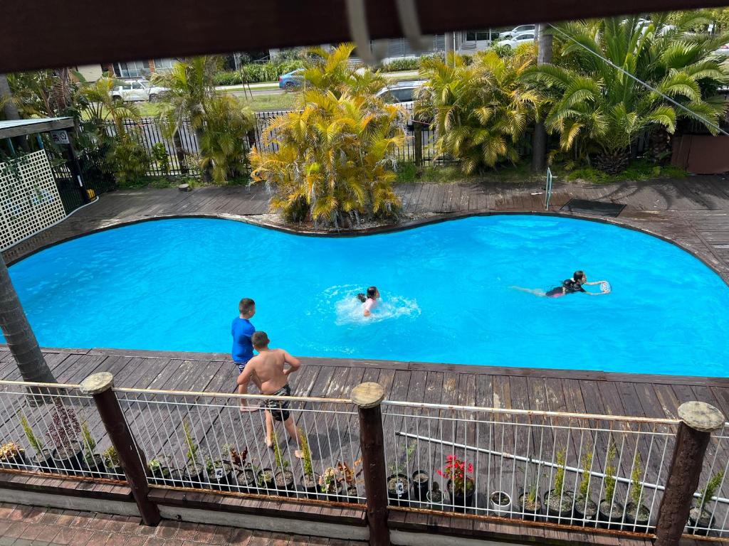 - un groupe de personnes se baignant dans une piscine dans l'établissement Central Jetty Motel, à Entrance