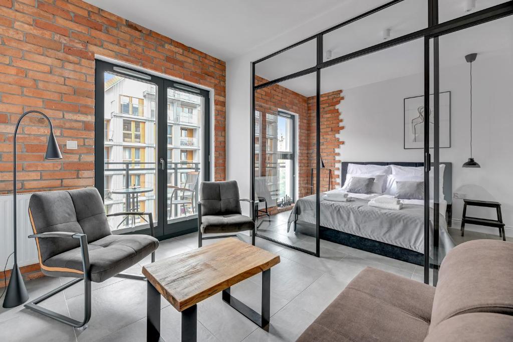 a bedroom with a bed and a brick wall at Downtown Apartments Aura III in Gdańsk