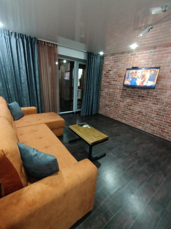 a living room with a couch and a tv at Уютная и просторная квартира в 50 метрах от городского парка in Petropavlovsk