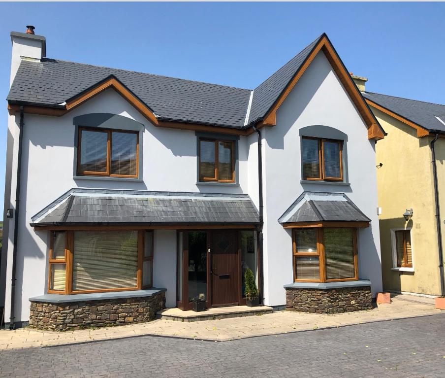 a white house with a black roof at Picturesque Riverside Home in Cahersiveen