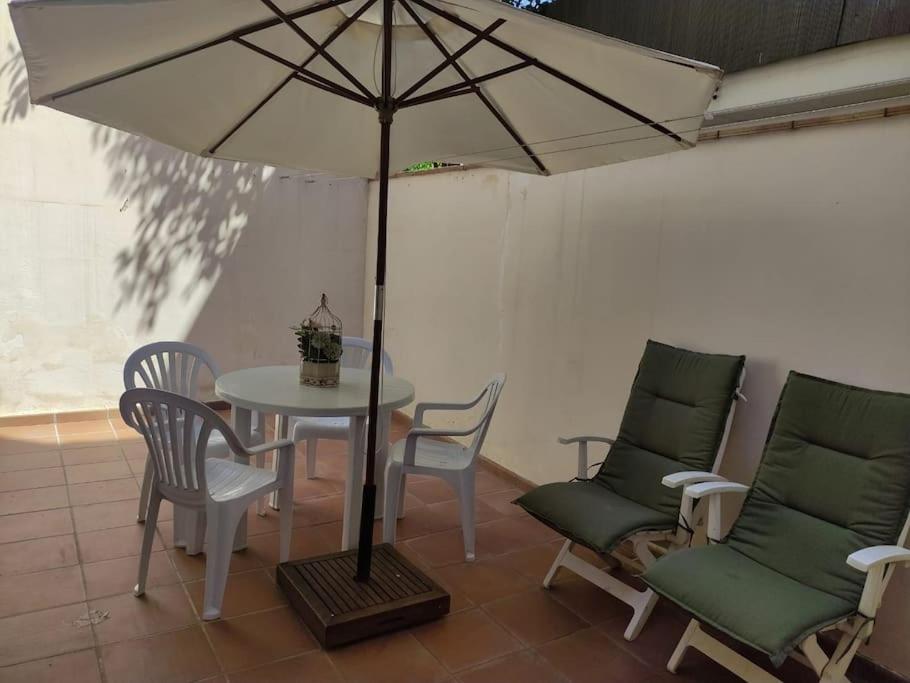 una mesa y sillas con una mesa y una sombrilla en Cozy flat with terrace en Palamós