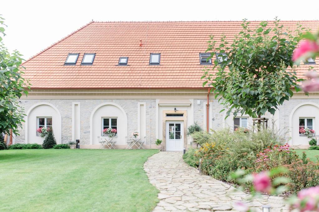 a white house with a red roof and a yard at Na Kmíně in Obříství