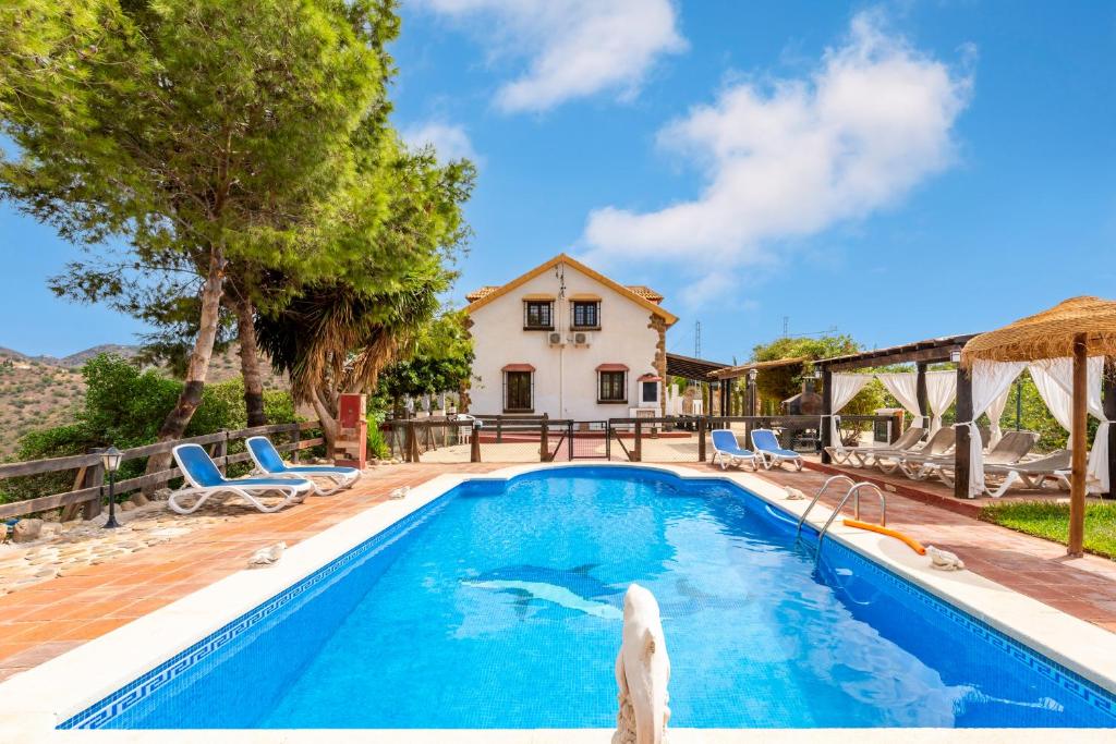 - une piscine en face d'une maison dans l'établissement Casa Rural Loma El Letrao, à Almogía