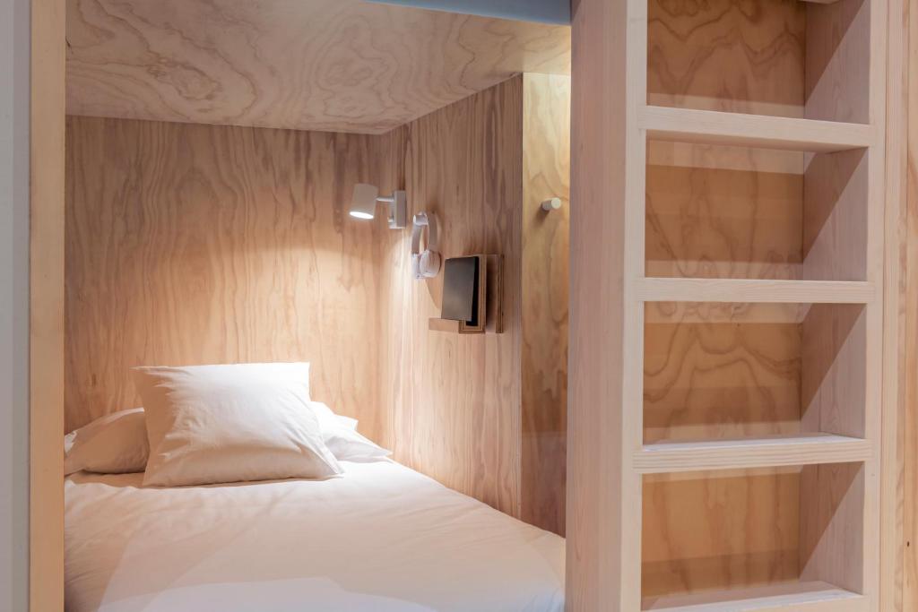 1 dormitorio con 1 cama con estante empotrado en Colo Colo Hostel - Single Private Beds, en San Sebastián