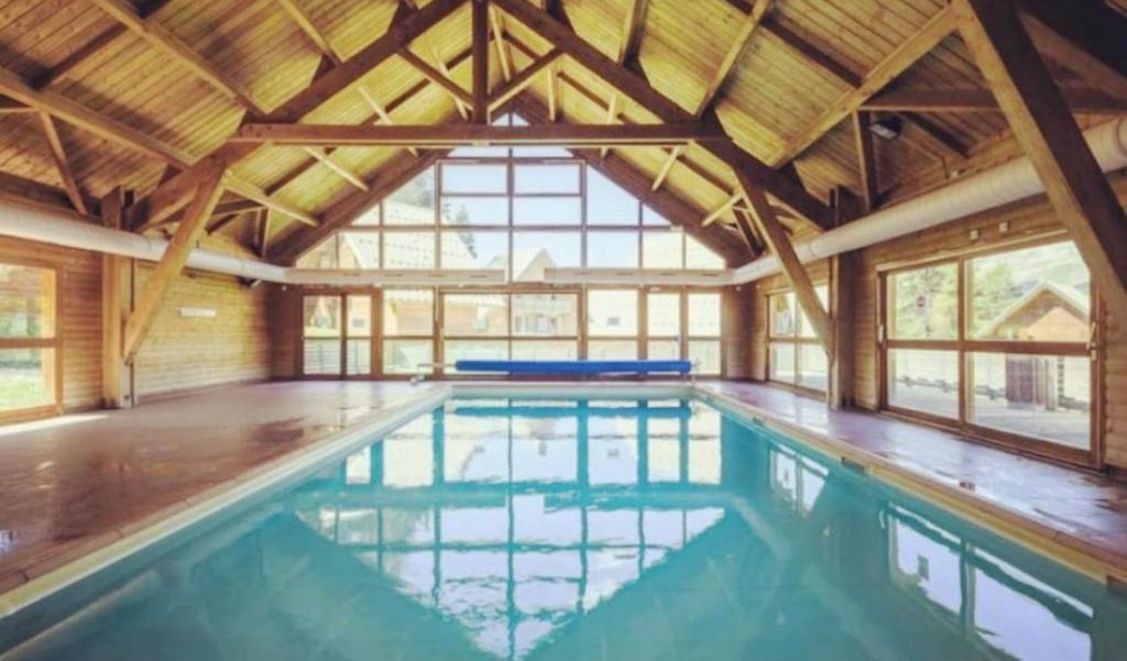 a large swimming pool with a large ceiling at Chalet La joue du Loup in Le Dévoluy