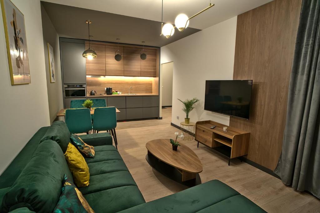 sala de estar con sofá verde y TV en Apartament Witold en Biała Podlaska