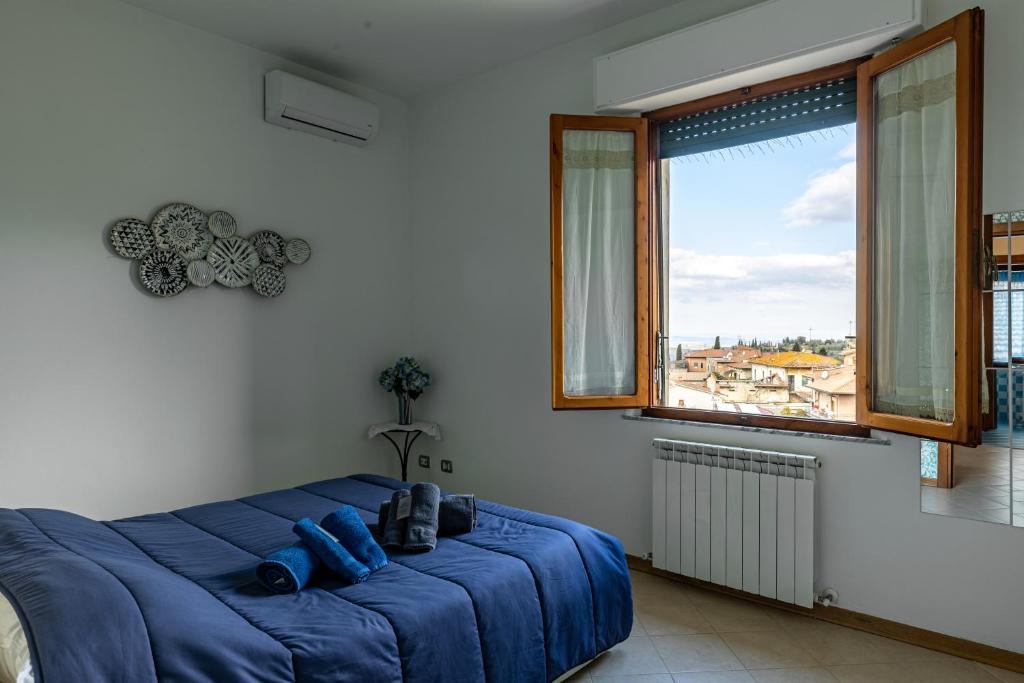 a large blue bed in a room with a window at Il Trabucco e La Terrazza della Val d' Orcia in San Quirico dʼOrcia