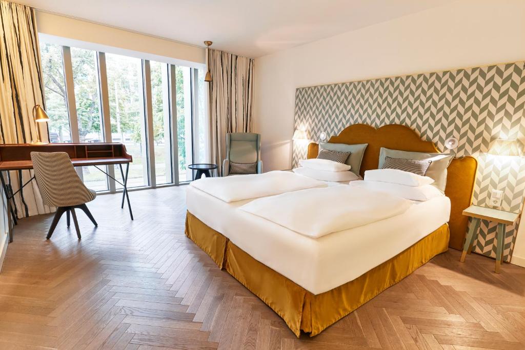 una camera d'albergo con un letto grande e una scrivania di MAXX by Steigenberger Vienna a Vienna