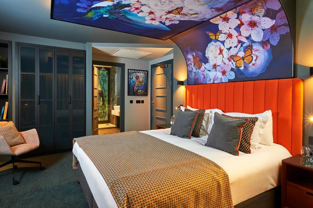 Malmaison Manchester Deansgate في مانشستر: غرفة نوم مع سرير كبير مع اللوح الأمامي من البرتقال