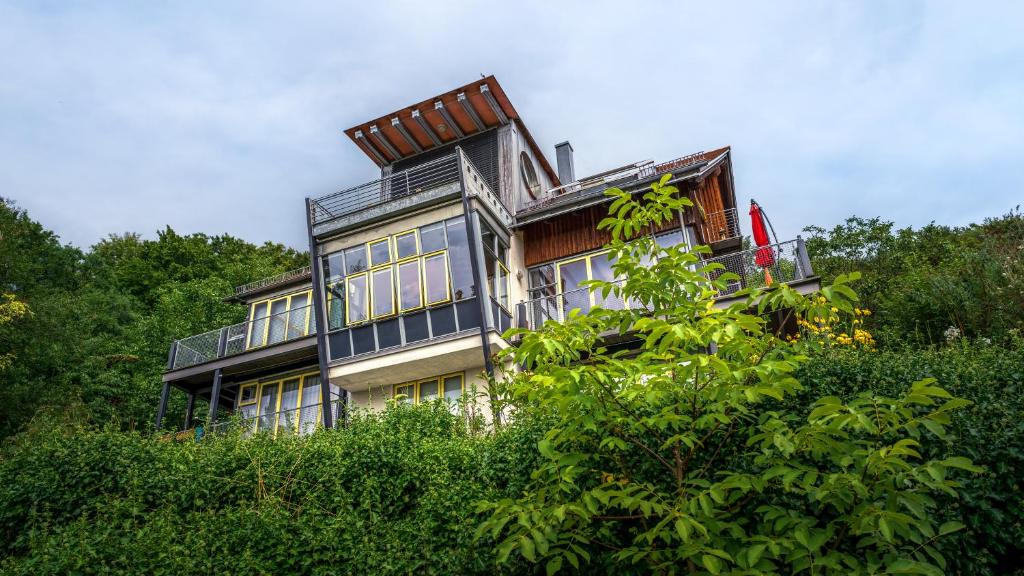 uma casa grande no topo de uma colina com árvores em Wunderschöne Ferienwohnung am Glatzenstein im Nürnberger Land 