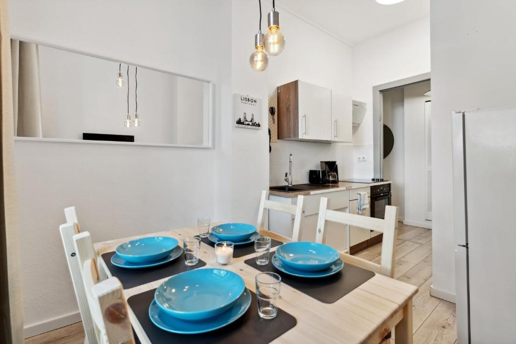 una cocina con una mesa con placas azules. en Sweet Central Tiny Apartment for 4 People, en Berlín