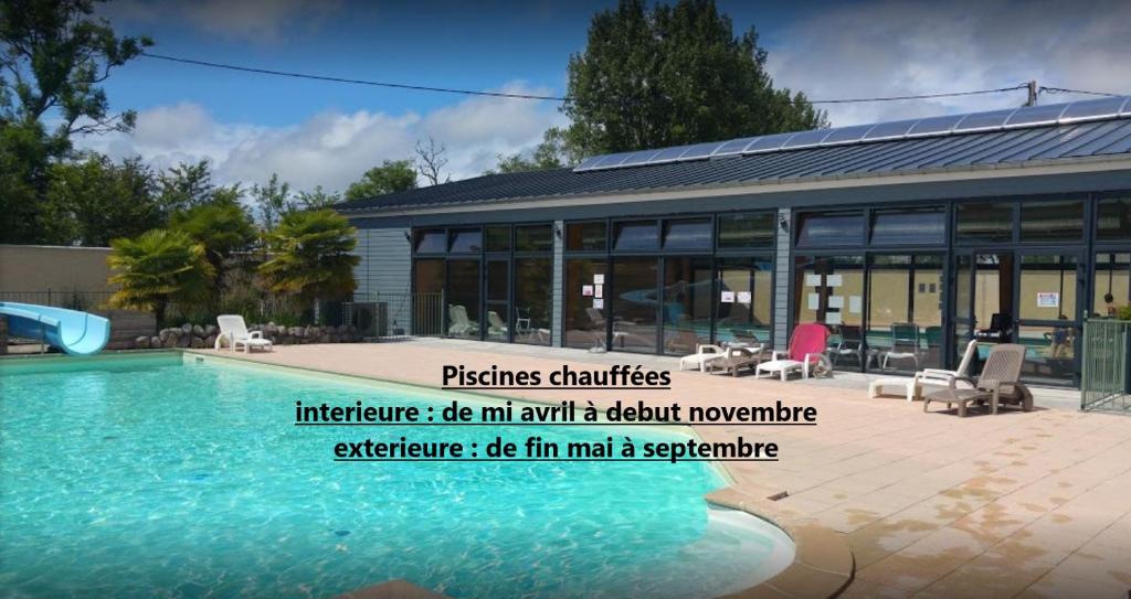 a swimming pool in front of a building at Camping la Haie Penée **** in Saint-Quentin-en-Tourmont